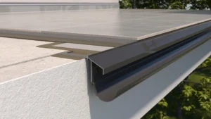 Zbliżenie na krawędź tarasu z zamontowanym profilem okapowym K100 i rynną, ukazujące sposób osadzenia posadzki ceramicznej, podkładu cementowego oraz odprowadzenie wody poza elewację.