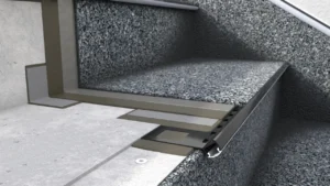 Zbliżenie na profil schodowy z oświetleniem LED przy stopniu z posadzką żywiczną typu kamienny dywan, pokazujące warstwy i sposób montażu.