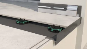 Profil okapowy tarasu wentylowanego z zamontowanymi regulowanymi wspornikami pod płyty ceramiczne, zapewniający stabilne podparcie i skuteczne odprowadzanie wody na krawędzi tarasu.