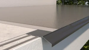 Krawędź tarasu z zamontowanym profilem okapowym, widok z boku na połączenie posadzki z profilem i podkładem.
